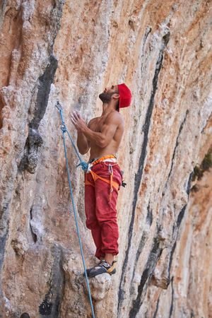 Shirtless climber standing on rocky slope