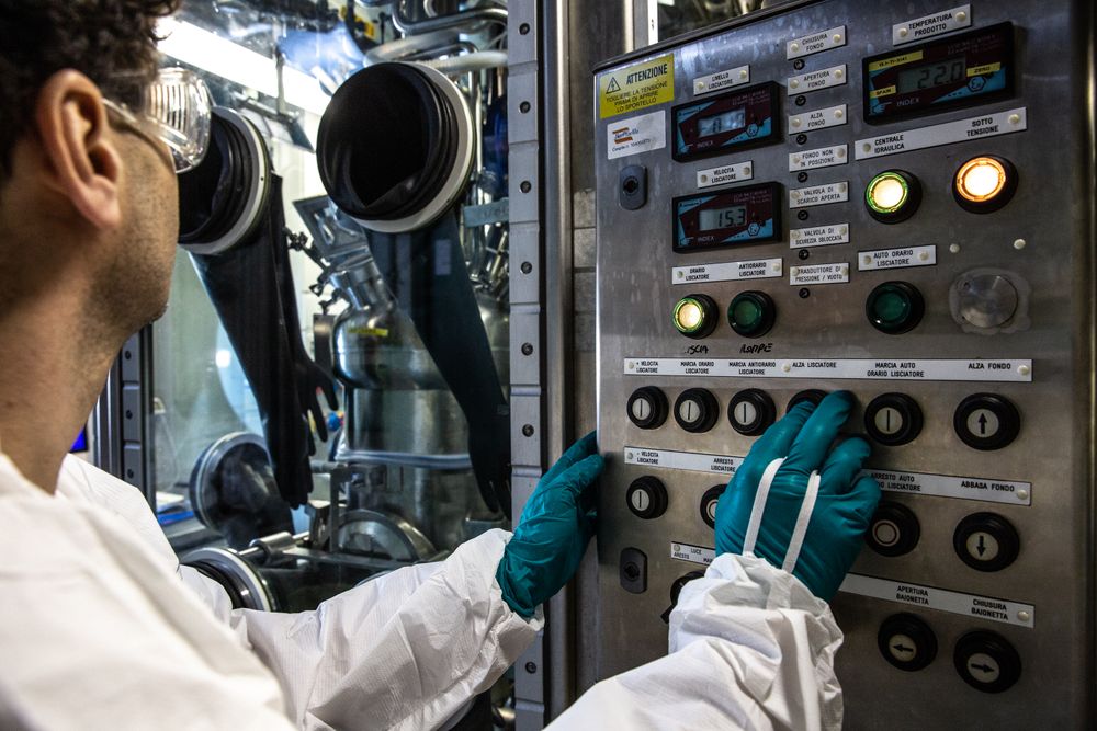 Man wearing goggle turning a button in an operating machine