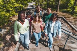 Multi-ethnic group of students walking up stairs on campus