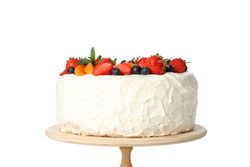 Berry cream cake on wooden stand isolated on blank background