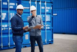 Two men in hard hats discussing a building project