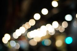 Bright night lights, unfocused along city street