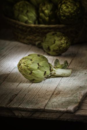 Green artichoke on wooden table