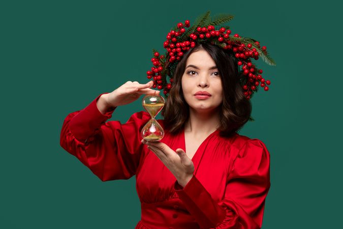 Elegant woman in red holding hourglass