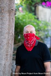 Man with red bandana outside by tree 5r92l0