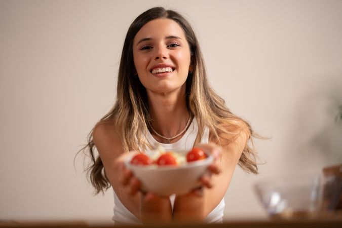 Smiling woman holding healthy salad bowl fresh vegetables happiness wellness lifestyle nutrition diet joy