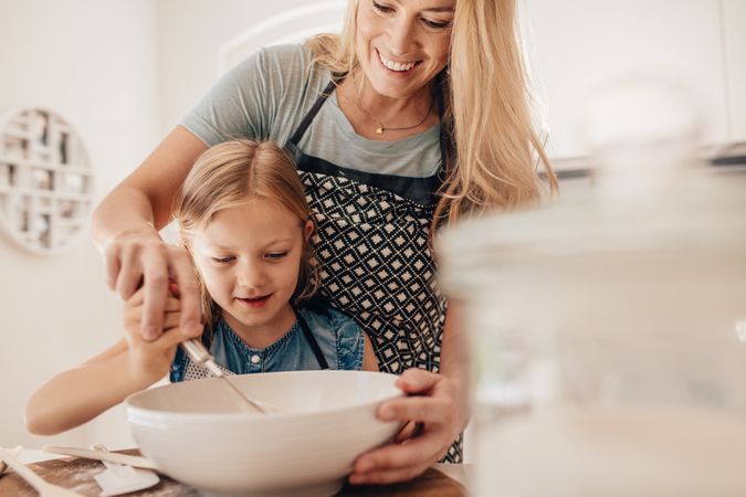 Mother and daughter mixing dough for baking