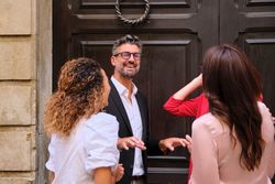 Cheerful coworkers standing at entrance of building and talking