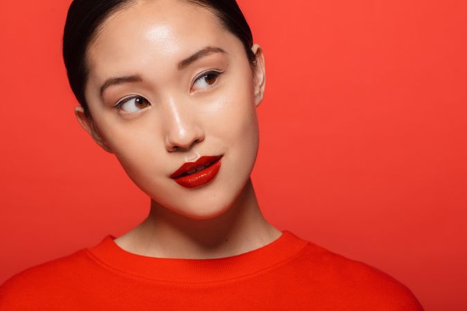 Korean female model with red makeup against red background