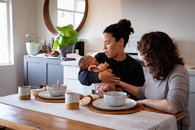 Two women with baby at their dining table