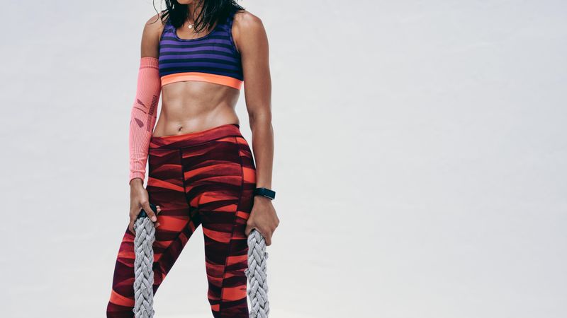 Cropped shot of a woman in fitness wear working out using battle ropes