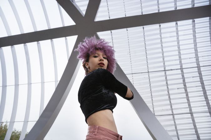 Stylish woman with pink hair looking at camera