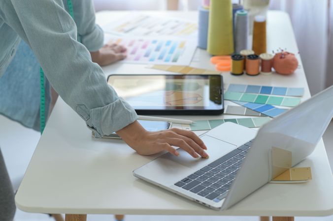 Person standing at desk with laptop