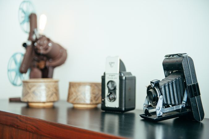Close up of vintage film camera with vintage pottery and cameras in background