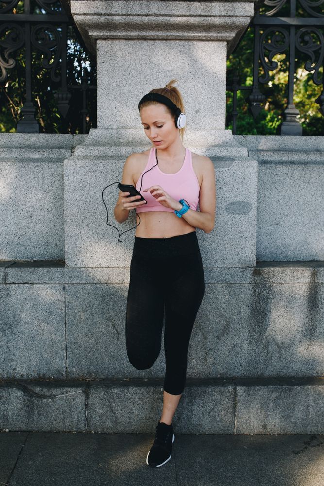 Woman with sportswear listening to music with headphones