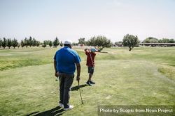 Back view of two men playing golf 4A9Y64