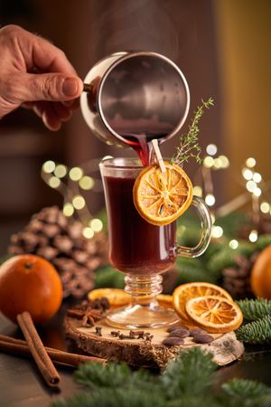 Faceless person pouring mulled wine into glass