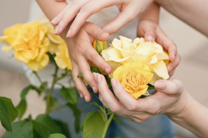 Mother and child holding yellow roses. Background flowers