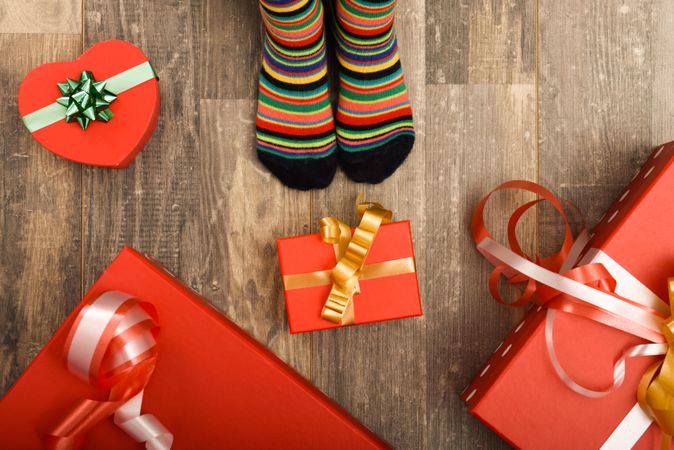 Christmas presents on wooden floor with small feet in socks