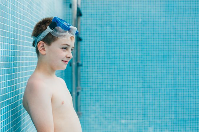 Boy with ball standing in empty pool