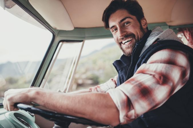 Smiling man driving a van on roadtrip