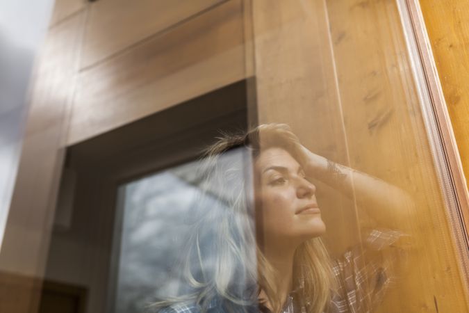 Woman reflection in a windows at home