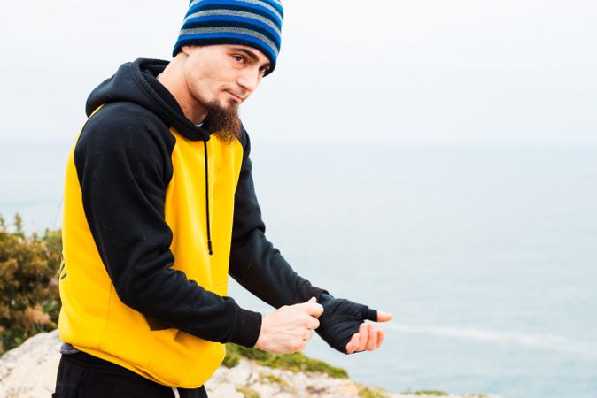 Male kickboxer bandaging hand for training