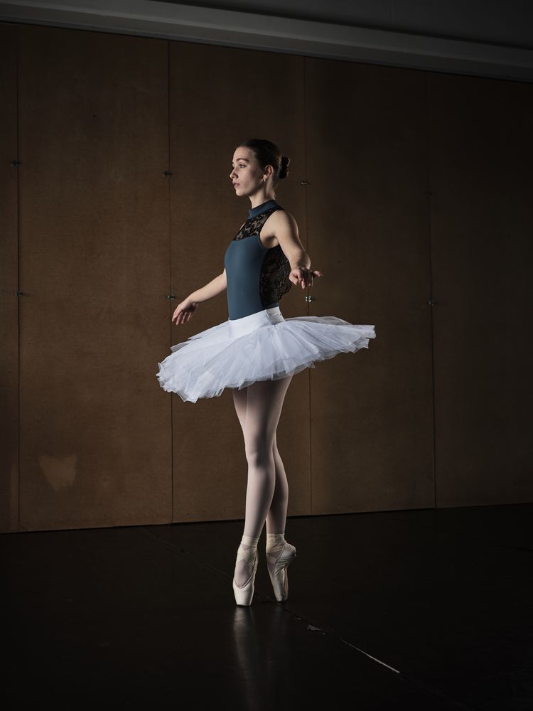 Graceful ballerina standing on tiptoes in pointe shoes