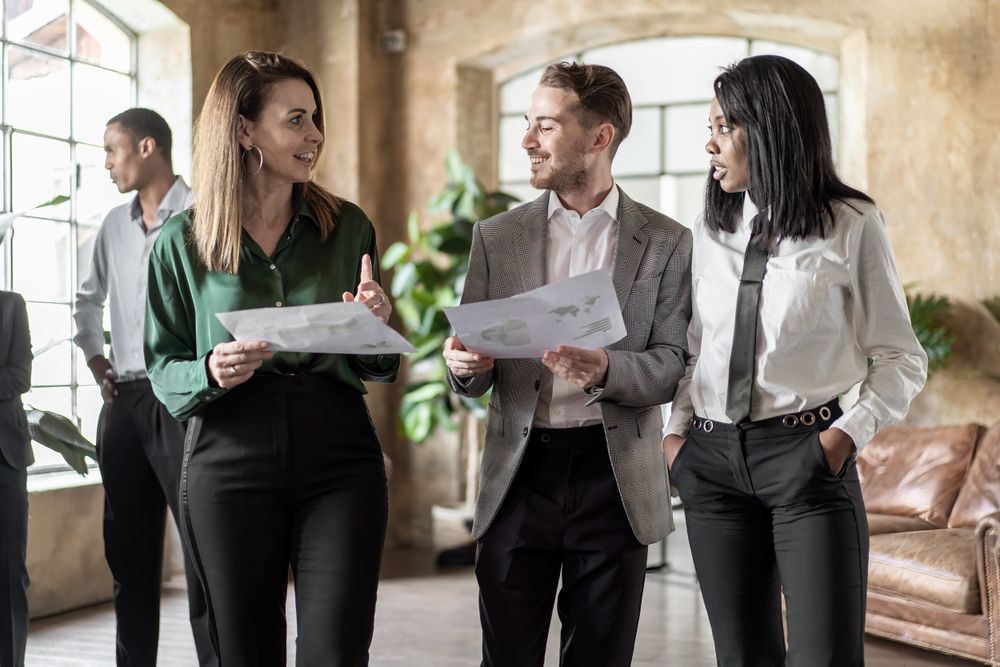 Multi-ethnic co-workers discussing a project standing together