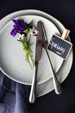 Top view of spring table setting for dinner with delicate purple flowers