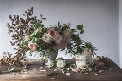 plate with cake decorated flower on table with bouquet of blooms in vase