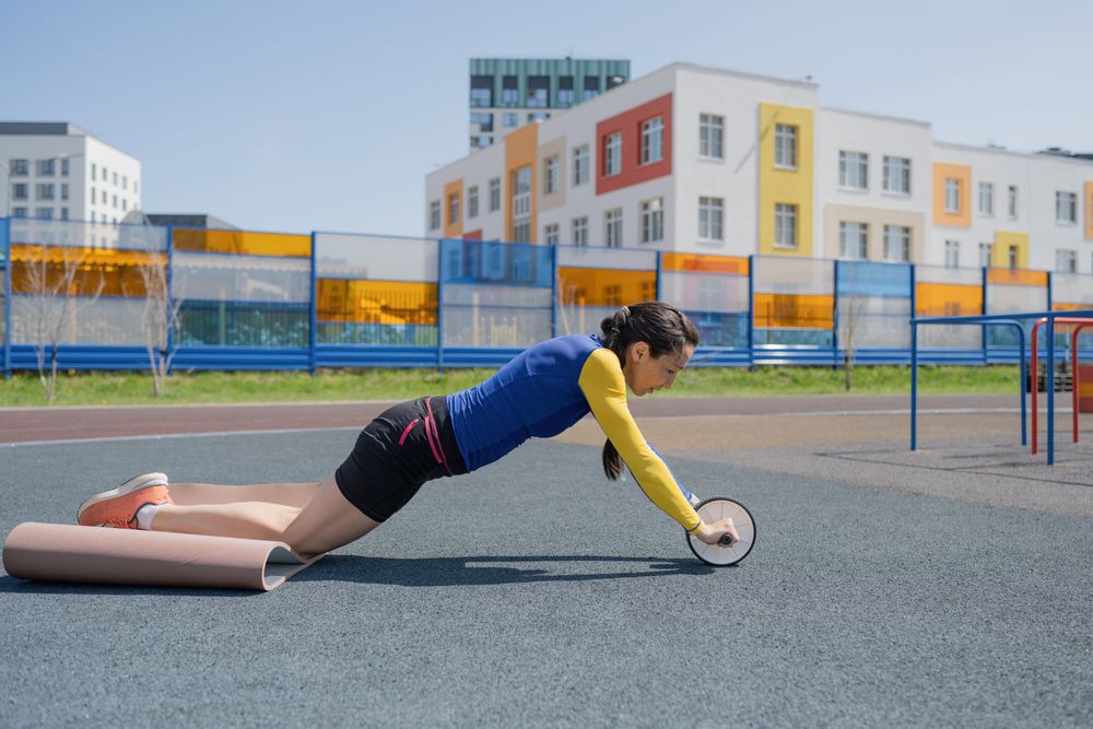 A young woman does an exercise at the stadium
