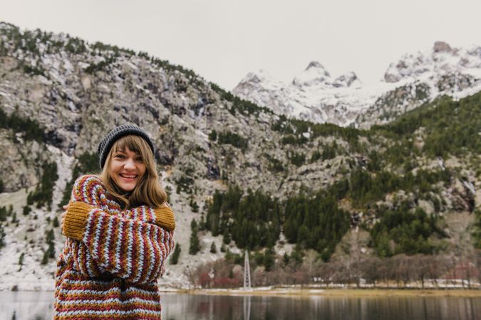 Young woman with crossed hands near mountain