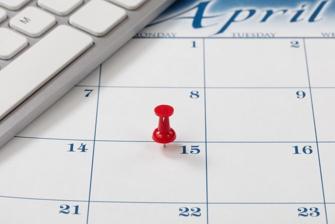 Income tax reminder on calendar with red pushpin