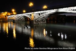Triana Bridge over Guadalquivir river at sunset with river reflections 4AzMpW