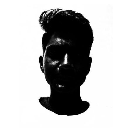 Dark statue of young man's head against light background