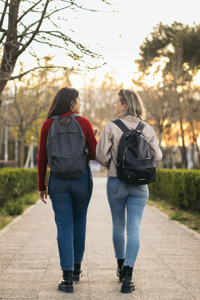 Back view of two students walking and talking