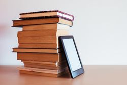 Vintage books next to an e-Book
