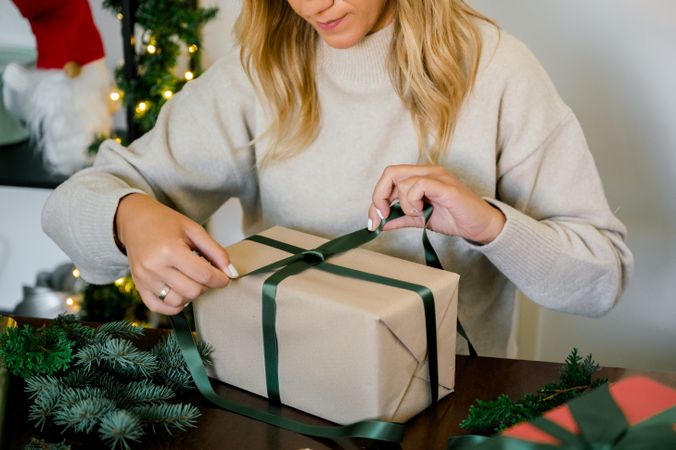 woman wrapping christmas gift at home