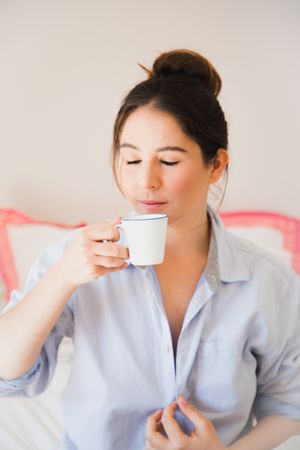 woman drinking coffee with closed eyes