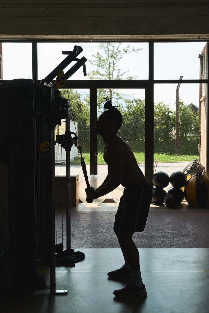 Black guy using exercise machine in gym