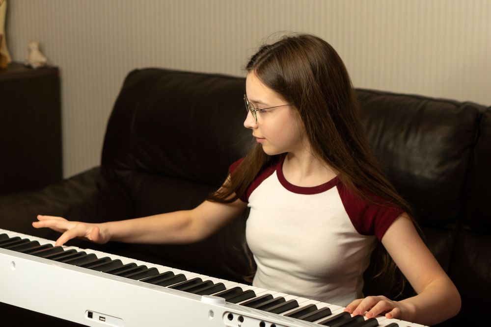 Girl playing the piano, focusing on the keys.