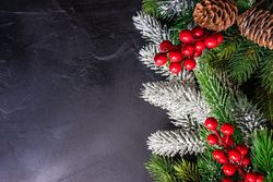 Christmas frame with holly on dark table background