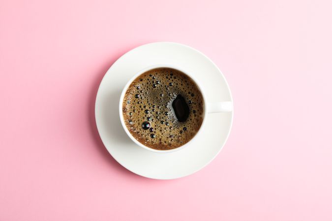 Cup of coffee on color background, space for text