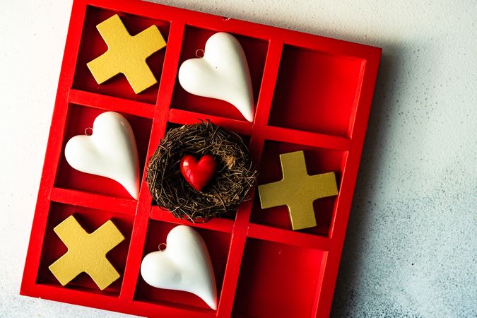St. Valentine day card concept with heart in nest in center of tic-tac-toe game