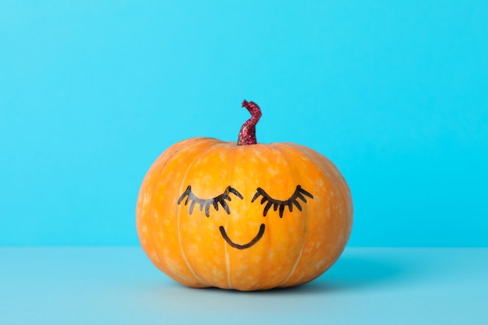 Pumpkin with smile on blue background, space for text