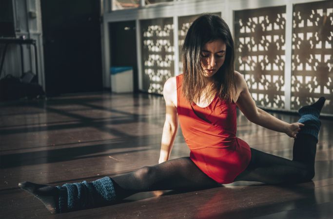 Young woman doing splits while stretching