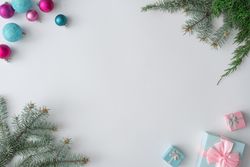 Christmas decorations, gifts with branches on corners of light background