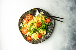 Top view of pasta with spinach and tomatoes