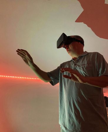 Man wearing virtual reality headset in red lit room